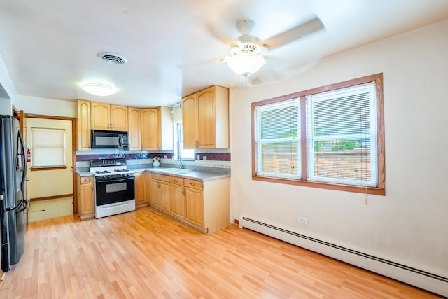 2418 S 58th Ave, Cicero, IL 60804 - kitchen with black appliances, a baseboard heating unit, light brown cabinetry, light wood finished floors, and light countertops