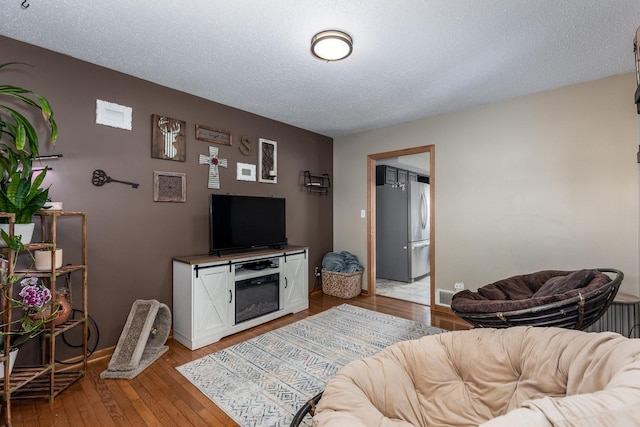 2020 Autumnwood Dr, Ottawa, IL 61350 - living room featuring light wood-type flooring, radiator, and a textured ceiling