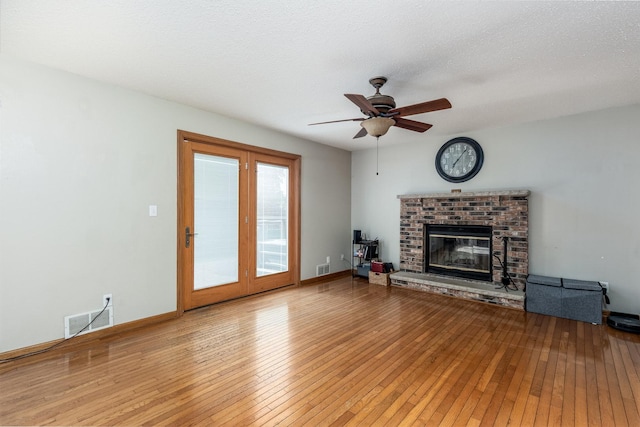 2020 Autumnwood Dr, Ottawa, IL 61350 - unfurnished living room featuring a brick fireplace, wood-type flooring, a ceiling fan, and a textured ceiling