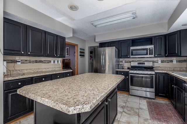 2020 Autumnwood Dr, Ottawa, IL 61350 - kitchen featuring stainless steel appliances, dark cabinetry, tasteful backsplash, light countertops, and a center island