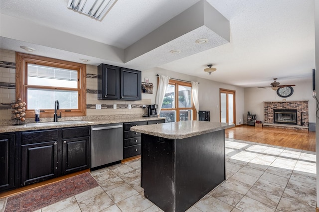 2020 Autumnwood Dr, Ottawa, IL 61350 - kitchen with dishwasher, dark cabinetry, a brick fireplace, and light countertops