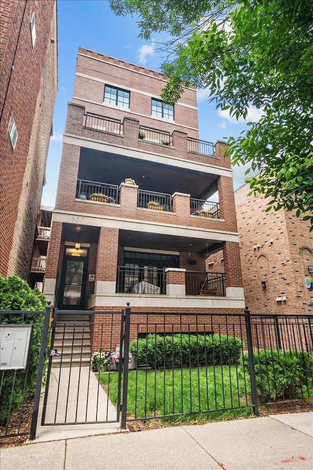 657 W Melrose St Unit 2, Chicago, IL 60657 - view of front of house featuring brick siding, a fenced front yard, a gate, and a balcony