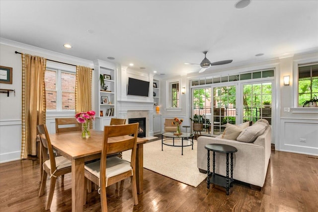 657 W Melrose St Unit 2, Chicago, IL 60657 - dining space with ornamental molding, a ceiling fan, a glass covered fireplace, a decorative wall, and dark wood finished floors