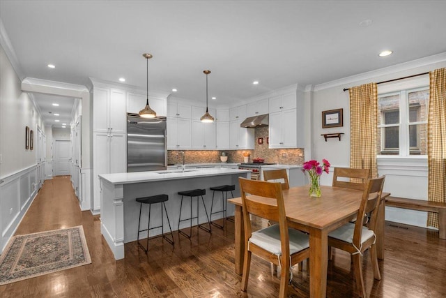 657 W Melrose St Unit 2, Chicago, IL 60657 - dining area with crown molding, dark wood-style floors, recessed lighting, a wainscoted wall, and a decorative wall