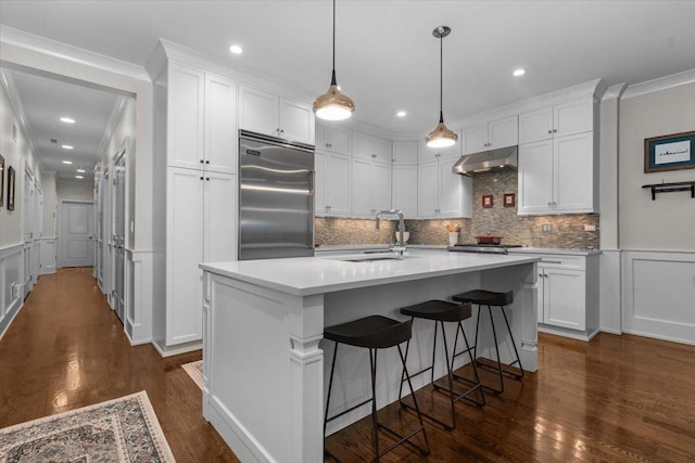 657 W Melrose St Unit 2, Chicago, IL 60657 - kitchen featuring under cabinet range hood, stainless steel built in fridge, white cabinetry, tasteful backsplash, and dark wood-style flooring