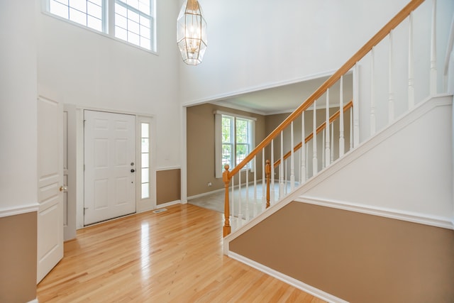 24625 Woodstock Dr, Plainfield, IL 60585 - foyer entrance featuring stairway, wood finished floors, a high ceiling, and a chandelier