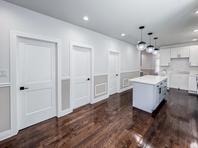 7755 S Wolcott Ave, Chicago, IL 60620 - kitchen featuring dark wood-style floors, white cabinetry, decorative light fixtures, light stone counters, and recessed lighting