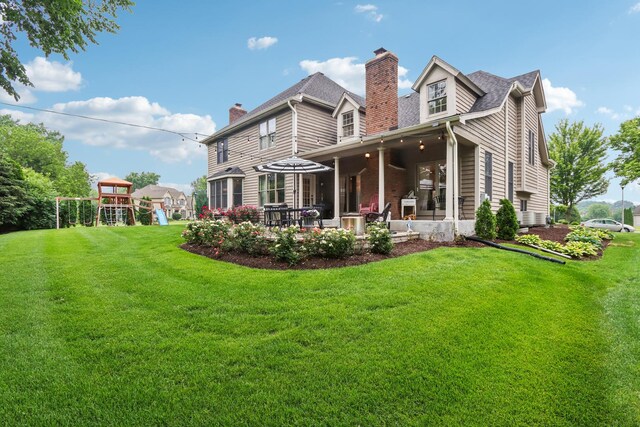 51 Mitchell Cir, Wheaton, IL 60189 - view of grassy yard featuring a patio area and a playground