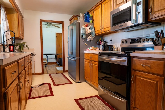 17848 W Fairfield Ln, Grayslake, IL 60030 - kitchen featuring stainless steel appliances, brown cabinetry, tasteful backsplash, a ceiling fan, and light countertops