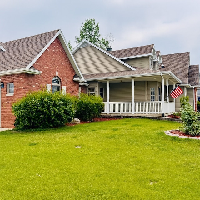 1102 Brian Dr, Manteno, IL 60950 - view of front of home with a shingled roof, a front lawn, and a porch