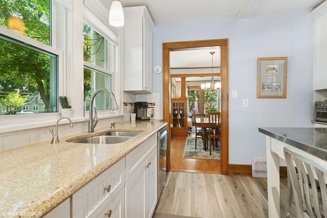 300 W Fremont St, Arlington Heights, IL 60004 - kitchen with light wood-style flooring, white cabinets, decorative backsplash, and light stone countertops