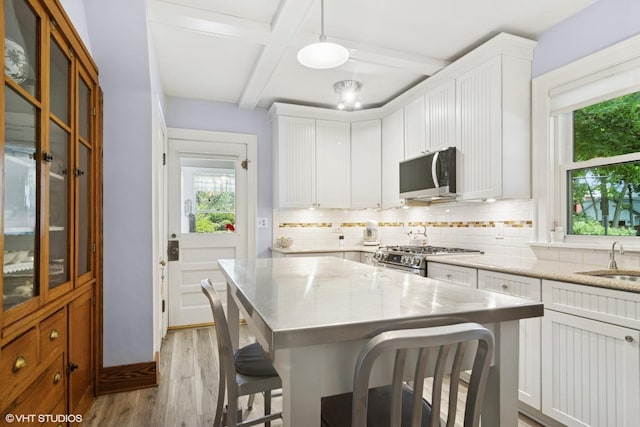 300 W Fremont St, Arlington Heights, IL 60004 - kitchen featuring appliances with stainless steel finishes, light wood finished floors, decorative backsplash, plenty of natural light, and coffered ceiling