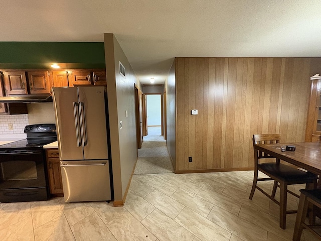 126 N Randolph St, Princeton, IL 61356 - kitchen featuring high end fridge, black range with electric cooktop, under cabinet range hood, backsplash, and light countertops