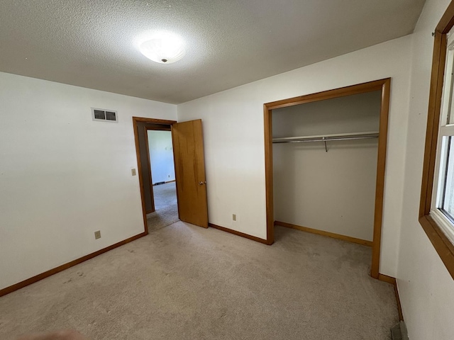 126 N Randolph St, Princeton, IL 61356 - unfurnished bedroom with light carpet, a textured ceiling, and a closet