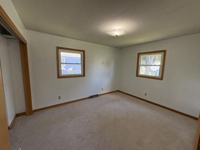 126 N Randolph St, Princeton, IL 61356 - unfurnished bedroom with light carpet, a closet, and a textured ceiling