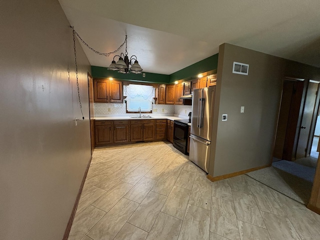 126 N Randolph St, Princeton, IL 61356 - kitchen with electric range, high quality fridge, a chandelier, light countertops, and tasteful backsplash