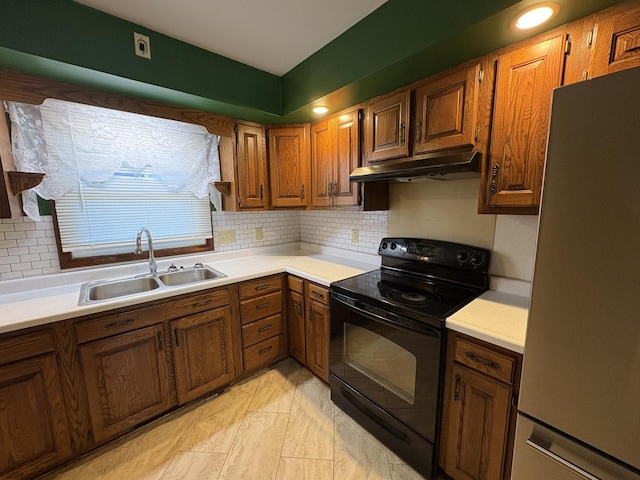 126 N Randolph St, Princeton, IL 61356 - kitchen with freestanding refrigerator, under cabinet range hood, black electric range oven, light countertops, and backsplash