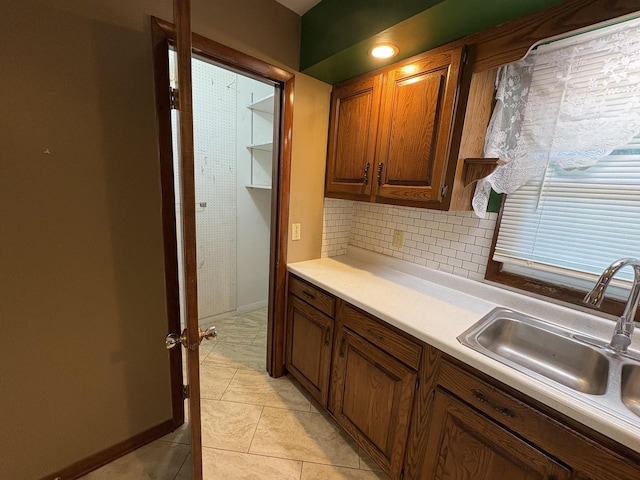 126 N Randolph St, Princeton, IL 61356 - kitchen featuring light countertops, light tile patterned floors, decorative backsplash, and brown cabinets