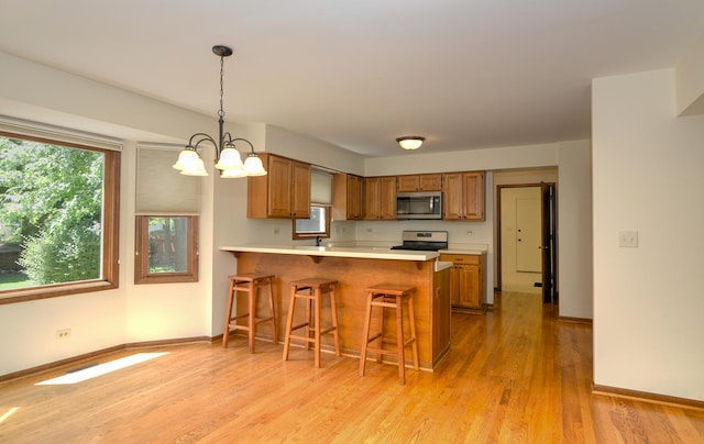 1268 Country Glen Ln, Carol Stream, IL 60188 - kitchen with appliances with stainless steel finishes, brown cabinetry, light countertops, and light wood-style floors