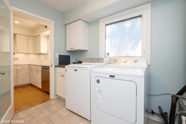 3231 Central St, Evanston, IL 60201 - laundry room featuring cabinet space, washing machine and dryer, and light tile patterned flooring