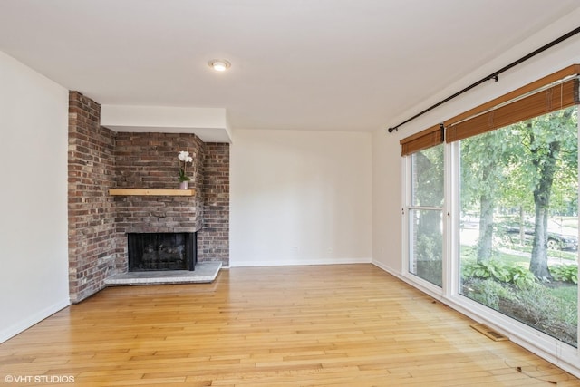 3231 Central St, Evanston, IL 60201 - unfurnished living room featuring a brick fireplace and hardwood / wood-style flooring
