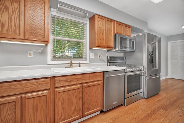 25034 S Center St, Channahon, IL 60410 - kitchen featuring appliances with stainless steel finishes, light countertops, light wood-type flooring, and brown cabinets