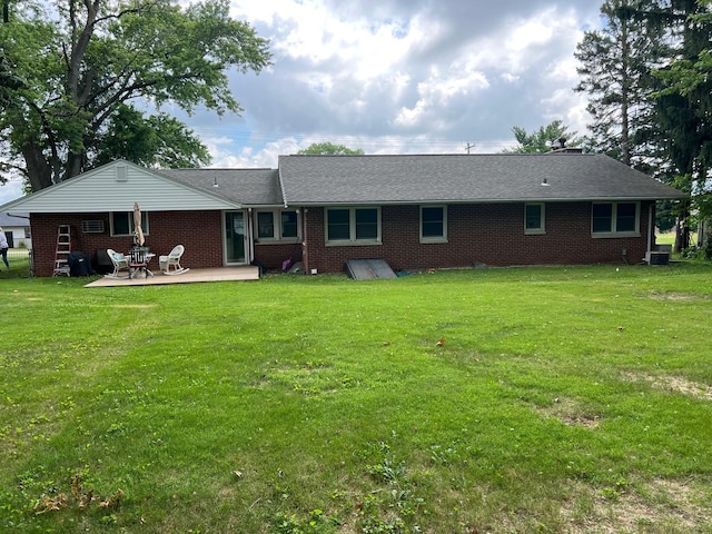 1006 Maple Hill Rd, Bloomington, IL 61705 - back of house with brick siding, a yard, and a patio