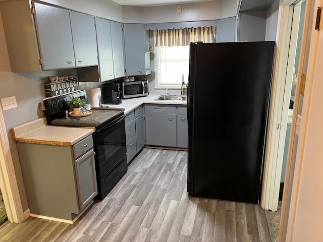 1006 Maple Hill Rd, Bloomington, IL 61705 - kitchen featuring black appliances, gray cabinets, light wood-style floors, and light countertops
