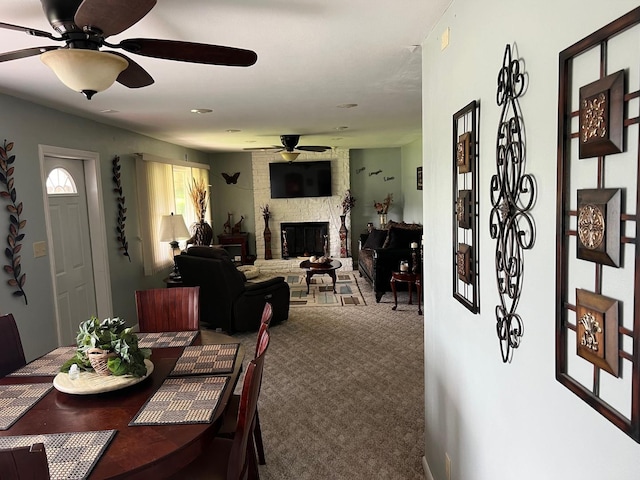 1006 Maple Hill Rd, Bloomington, IL 61705 - dining area featuring ceiling fan, carpet, and a fireplace