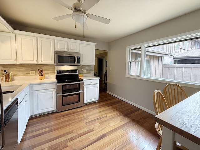 42W396 Hawthorne Ct, Saint Charles, IL 60175 - kitchen featuring appliances with stainless steel finishes, tasteful backsplash, light wood finished floors, white cabinetry, and light countertops