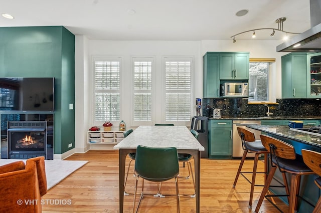 2145 W Crystal St Unit 2, Chicago, IL 60622 - kitchen featuring green cabinetry, appliances with stainless steel finishes, exhaust hood, decorative backsplash, and plenty of natural light
