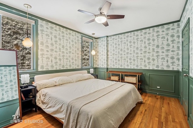 2145 W Crystal St Unit 2, Chicago, IL 60622 - bedroom featuring wallpapered walls, wood finished floors, a wainscoted wall, multiple windows, and crown molding