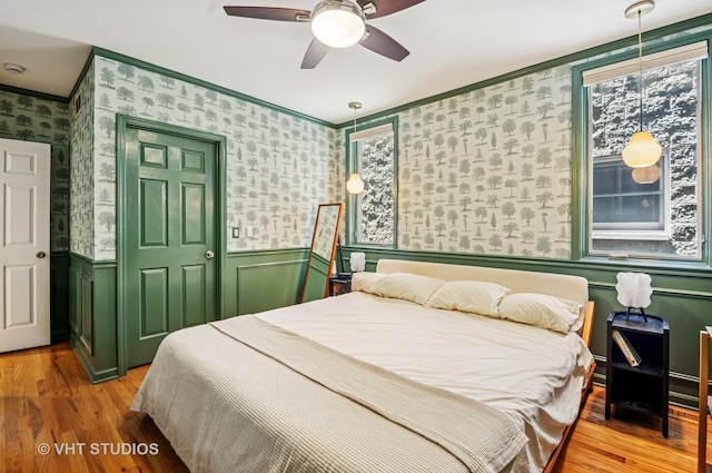 2145 W Crystal St Unit 2, Chicago, IL 60622 - bedroom featuring wallpapered walls, wainscoting, crown molding, light wood-style flooring, and a ceiling fan