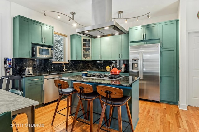 2145 W Crystal St Unit 2, Chicago, IL 60622 - kitchen featuring appliances with stainless steel finishes, island exhaust hood, green cabinetry, track lighting, and light wood-style flooring