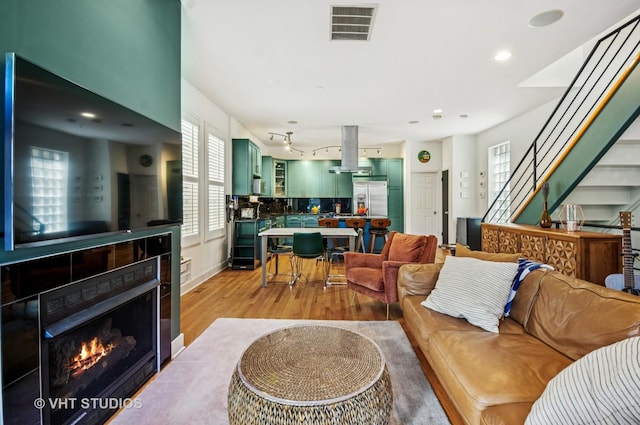 2145 W Crystal St Unit 2, Chicago, IL 60622 - living room featuring light wood-style floors, a tile fireplace, stairs, and recessed lighting