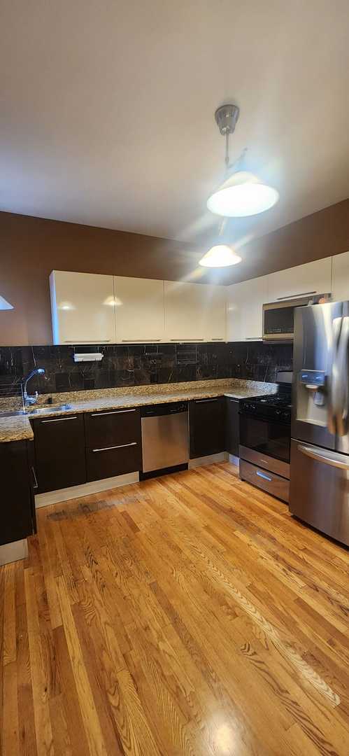 3700 W Cermak Rd Unit 1, Chicago, IL 60623 - kitchen featuring stainless steel appliances, decorative backsplash, light wood finished floors, white cabinetry, and stone countertops