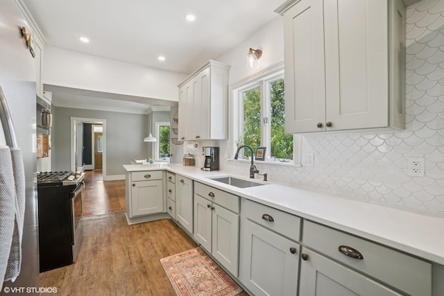 241 Hoy Ave, Woodstock, IL 60098 - kitchen with stainless steel range with gas cooktop, light wood-type flooring, light countertops, crown molding, and decorative backsplash