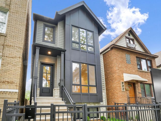 2248 W Ainslie St, Chicago, IL 60625 - view of front of property with board and batten siding, a fenced front yard, and entry steps