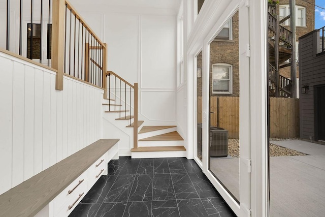 2248 W Ainslie St, Chicago, IL 60625 - entrance foyer featuring dark marble finish flooring, stairs, and a decorative wall