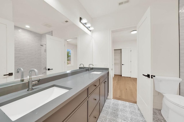2248 W Ainslie St, Chicago, IL 60625 - bathroom featuring double vanity, tiled shower, and recessed lighting