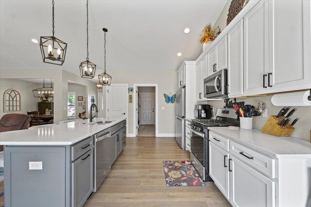 1807 E Fairfield Cir, Urbana, IL 61802 - kitchen with stainless steel appliances, a chandelier, light countertops, a kitchen island with sink, and white cabinets