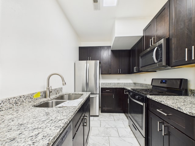 738 S Kedzie Ave Unit 3, Chicago, IL 60612 - kitchen featuring appliances with stainless steel finishes, light marble finish floors, light stone counters, and dark brown cabinetry