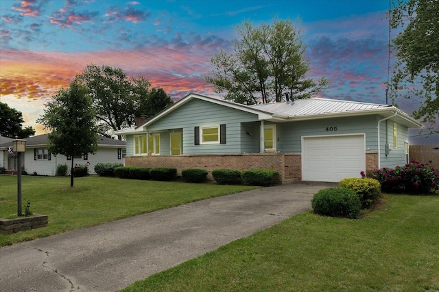 405 E Madison St, Pesotum, IL 61863 - ranch-style house featuring an attached garage, driveway, brick siding, a lawn, and a metal roof