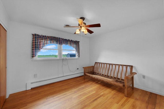 405 E Madison St, Pesotum, IL 61863 - unfurnished bedroom featuring baseboard heating, light wood-style floors, a closet, and ceiling fan