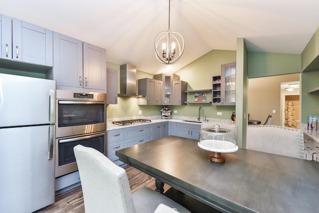 30W050 Willow Ln Unit 30W050, Warrenville, IL 60555 - kitchen featuring appliances with stainless steel finishes, wall chimney range hood, gray cabinetry, a chandelier, and wood finished floors