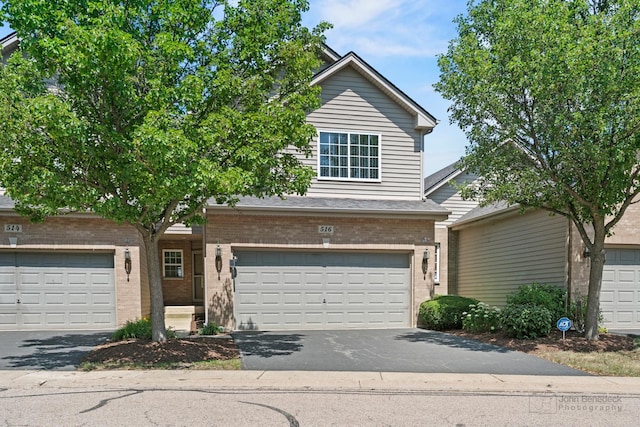 516 Madison Ln, Elgin, IL 60123 - view of front of home featuring brick siding, asphalt driveway, and a garage