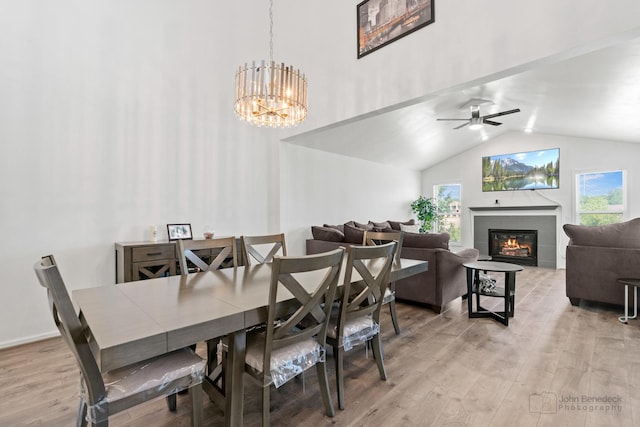 516 Madison Ln, Elgin, IL 60123 - dining space featuring a tiled fireplace, light wood-style floors, lofted ceiling, and a chandelier