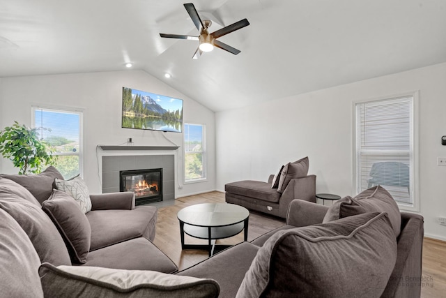 516 Madison Ln, Elgin, IL 60123 - living room featuring ceiling fan, lofted ceiling, a tiled fireplace, light wood-style floors, and healthy amount of natural light