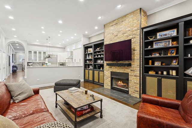 3547 N Fremont St Unit 1N, Chicago, IL 60657 - living area with arched walkways, ornamental molding, recessed lighting, a fireplace, and wood finished floors