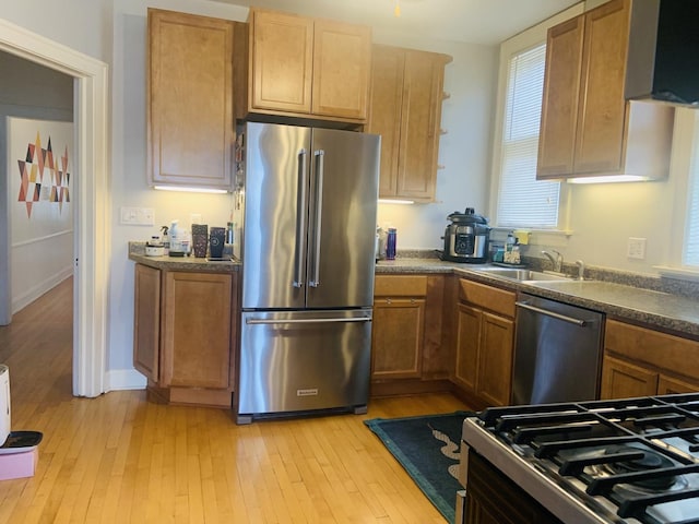 6712 N Maplewood Ave, Chicago, IL 60645 - kitchen with appliances with stainless steel finishes, light wood-style floors, dark countertops, and brown cabinetry